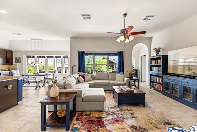 living room featuring arched walkways, visible vents, and light tile patterned floors