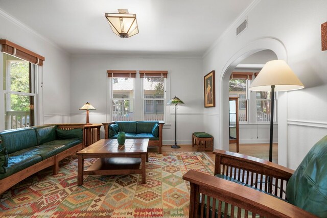 4103 Ave F, Austin, TX 78751 - living area featuring healthy amount of natural light, ornamental molding, a wainscoted wall, arched walkways, and wood finished floors