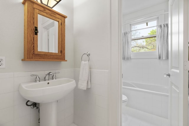 4103 Ave F, Austin, TX 78751 - full bathroom featuring tile walls, a relaxing tiled tub, toilet, and a wainscoted wall