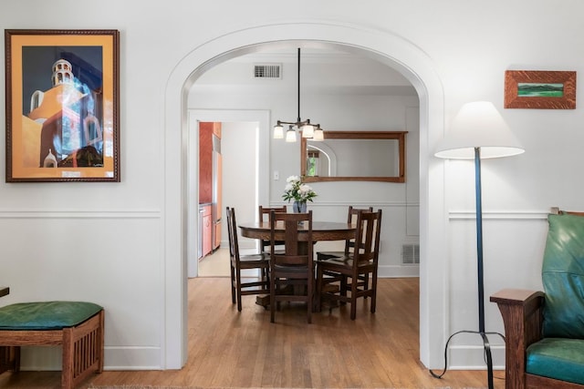 4103 Ave F, Austin, TX 78751 - dining area with light wood-style floors, arched walkways, a chandelier, and baseboards