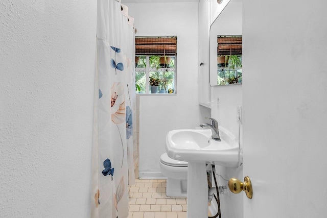 full bathroom featuring toilet, a shower with curtain, and tile patterned flooring