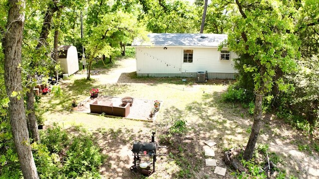 back of house with a storage unit and an outdoor structure