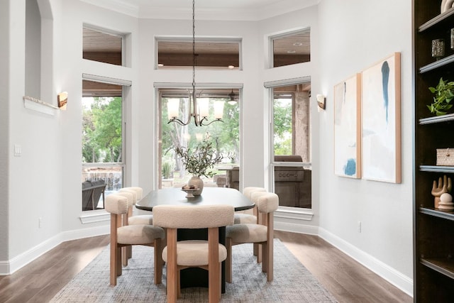 2304 High Lonesome, Leander, TX 78641 - dining area with a chandelier, baseboards, wood finished floors, a towering ceiling, and crown molding
