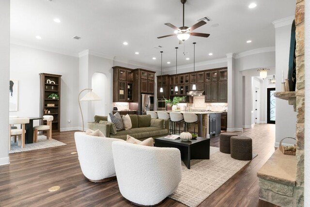 2304 High Lonesome, Leander, TX 78641 - living room featuring a ceiling fan, baseboards, recessed lighting, crown molding, and dark wood-type flooring