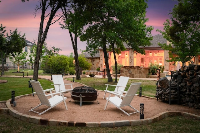 2304 High Lonesome, Leander, TX 78641 - patio terrace at dusk with an outdoor fire pit and a lawn