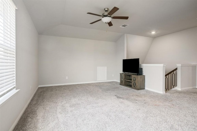10310 Mager Ln, Hutto, TX 78634 - unfurnished living room with a ceiling fan, carpet floors, vaulted ceiling, and baseboards