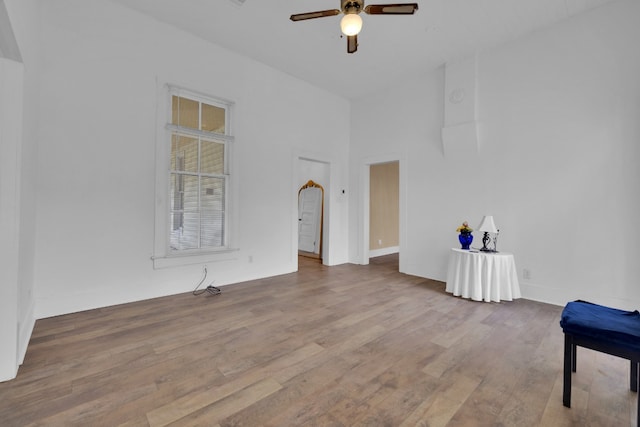 spare room featuring ceiling fan, baseboards, and wood finished floors