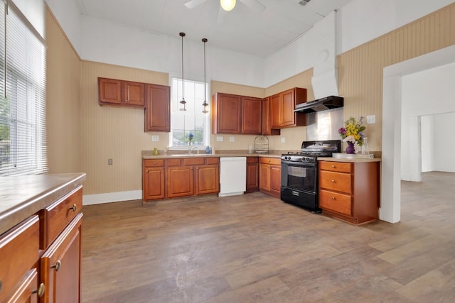 kitchen featuring wood finished floors, dishwasher, ceiling fan, wall chimney range hood, and black range with gas stovetop