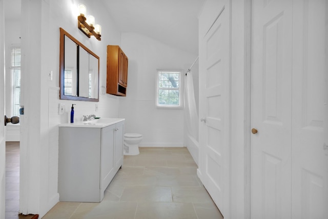 bathroom with toilet, vaulted ceiling, tile patterned flooring, curtained shower, and vanity