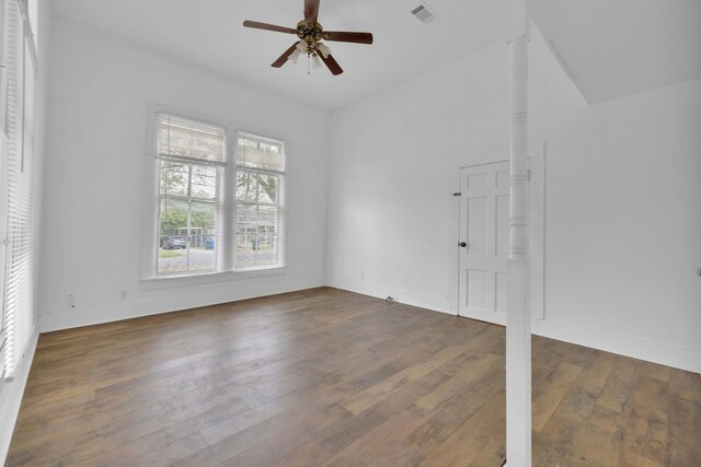 spare room with vaulted ceiling, wood finished floors, ceiling fan, baseboards, and visible vents