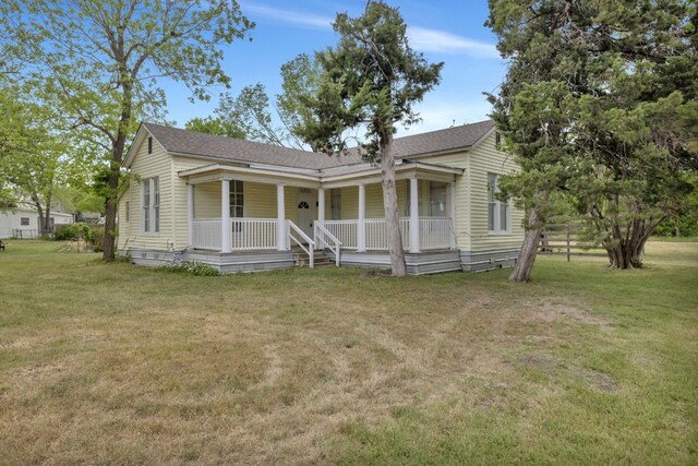 401 Shaw St, Taylor, TX 76574 - view of front of house with a porch, a front yard, and roof with shingles