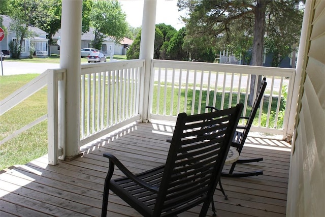 deck featuring a porch, a yard, and a residential view
