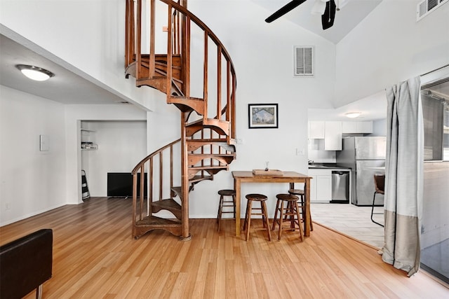 2500 Burleson Rd Unit 311, Austin, TX 78741 - dining area with high vaulted ceiling, a ceiling fan, light wood-type flooring, and stairs