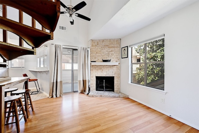 2500 Burleson Rd Unit 311, Austin, TX 78741 - unfurnished living room with ceiling fan, wood finished floors, baseboards, and a fireplace