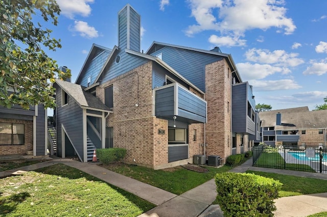 2500 Burleson Rd Unit 311, Austin, TX 78741 - view of home's exterior with brick siding, a chimney, a balcony, and stairs