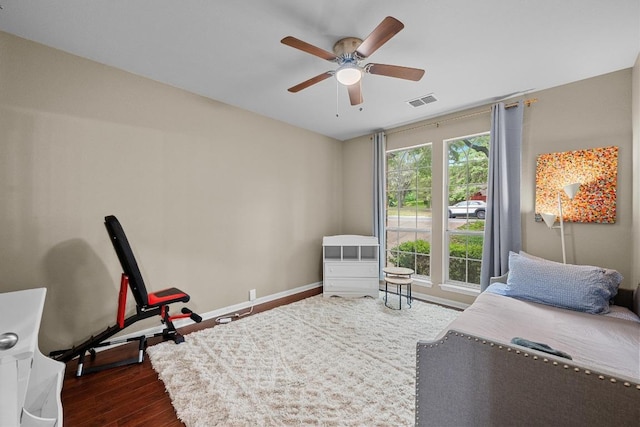 bedroom with dark wood finished floors, visible vents, a ceiling fan, and baseboards