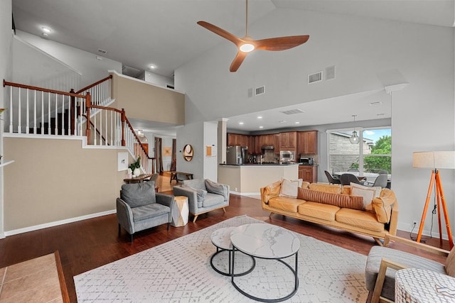 living area featuring a ceiling fan, baseboards, dark wood-style flooring, and visible vents