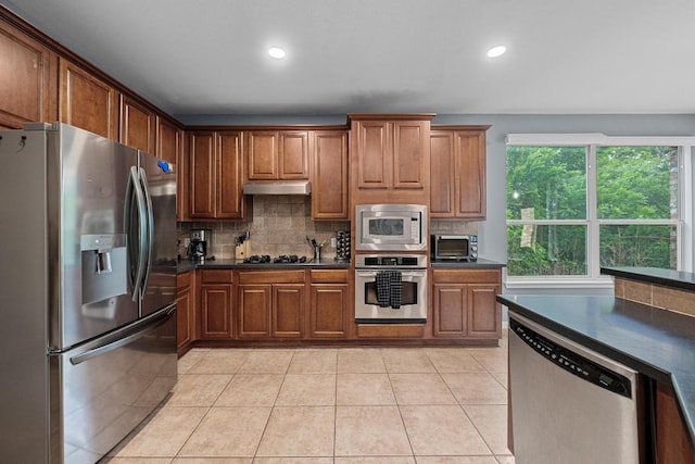 kitchen featuring dark countertops, appliances with stainless steel finishes, backsplash, under cabinet range hood, and recessed lighting