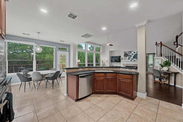 kitchen featuring stainless steel dishwasher, a ceiling fan, dark countertops, a sink, and visible vents