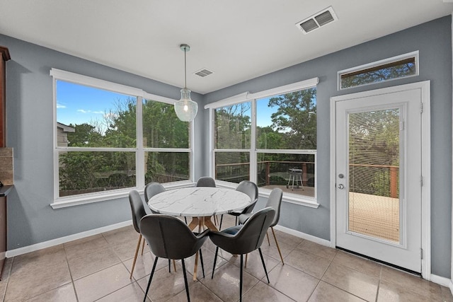 dining room featuring light tile patterned flooring, visible vents, and baseboards