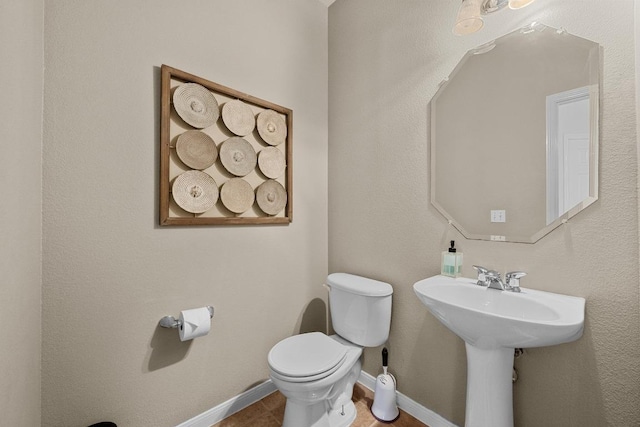 bathroom with toilet and baseboards