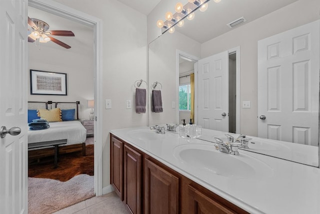 ensuite bathroom featuring tile patterned floors, double vanity, a sink, and ceiling fan