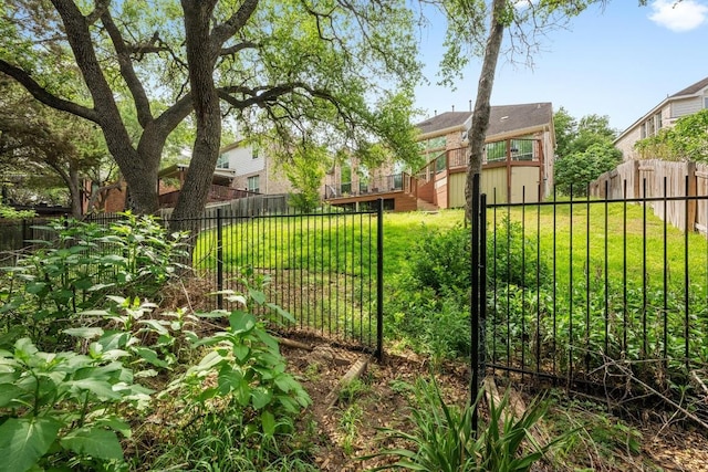 view of gate with a lawn, a fenced backyard, and stairs