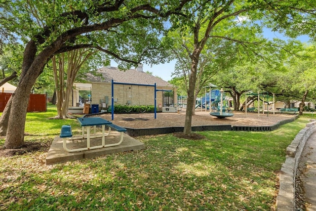 community jungle gym featuring a yard and fence