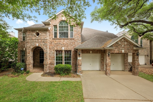traditional home featuring a front lawn, concrete driveway, brick siding, an attached garage, and a shingled roof