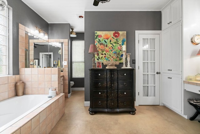full bathroom featuring a garden tub, vanity, a wealth of natural light, and toilet