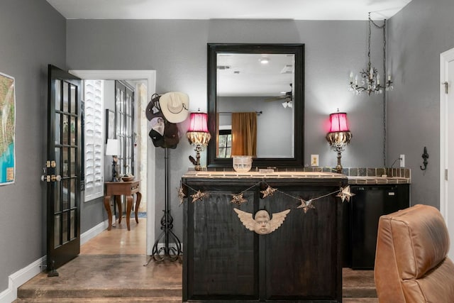 bar with a dry bar, fridge, baseboards, a ceiling fan, and wood finished floors