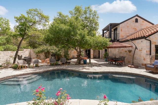 outdoor pool with fence and a patio area