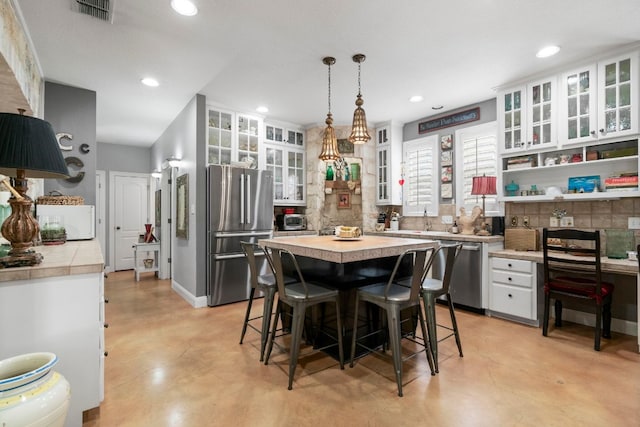dining space featuring a toaster, visible vents, recessed lighting, and finished concrete flooring