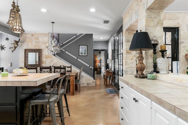 dining room featuring recessed lighting, visible vents, a notable chandelier, and finished concrete floors