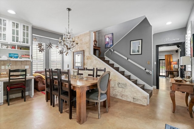 dining space with stairway, concrete flooring, an inviting chandelier, and recessed lighting