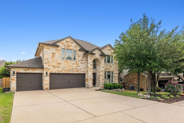 french country home with stone siding, driveway, a shingled roof, and a garage