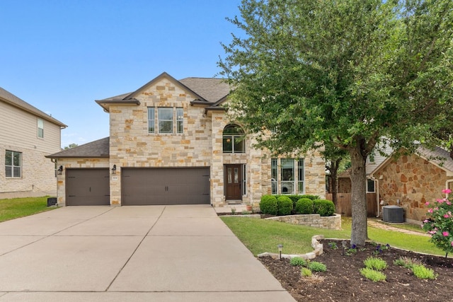view of front of house featuring stone siding, concrete driveway, a shingled roof, central air condition unit, and an attached garage