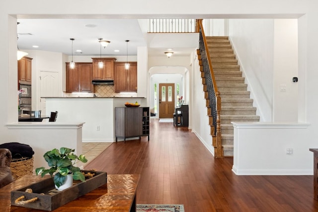 3614 Turkey Path Bnd, Cedar Park, TX 78613 - living area featuring dark wood-style floors, arched walkways, stairway, and recessed lighting