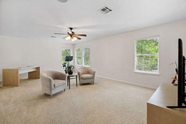 sitting room with ceiling fan, light carpet, and baseboards