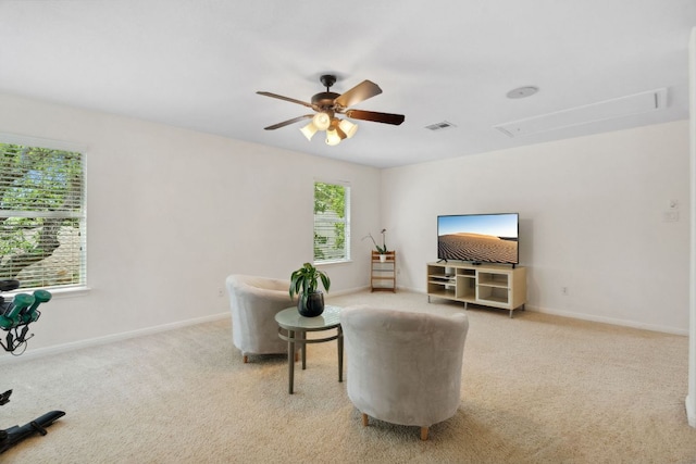 living area with attic access, carpet floors, ceiling fan, and baseboards