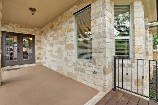 property entrance featuring stone siding and french doors
