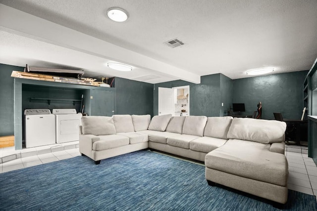 living room with tile patterned flooring, visible vents, beam ceiling, washing machine and clothes dryer, and a textured ceiling
