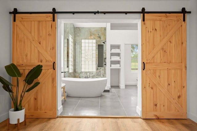 full bathroom with baseboards, a freestanding tub, a walk in shower, and tile patterned floors