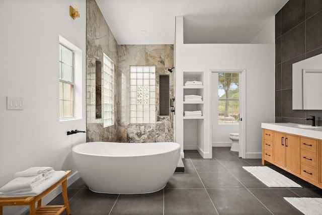 bathroom featuring tile patterned floors, baseboards, vanity, and toilet