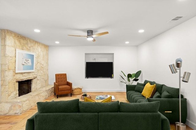 living area featuring wood finished floors, ceiling fan, a fireplace, visible vents, and recessed lighting