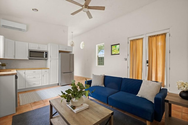 living room featuring an AC wall unit, lofted ceiling, a ceiling fan, and light tile patterned floors