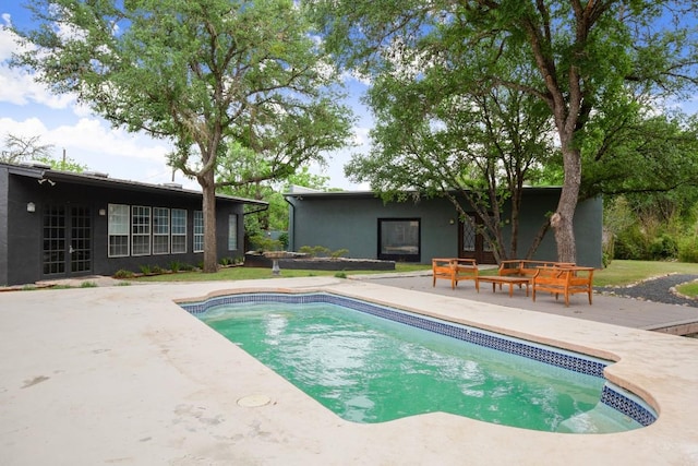 pool with a patio area and french doors