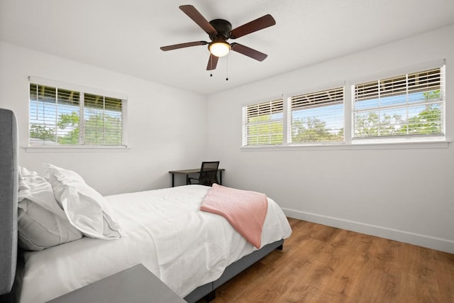 bedroom featuring wood finished floors, baseboards, and ceiling fan