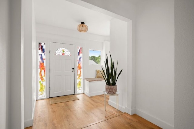foyer entrance with baseboards and light wood-style floors