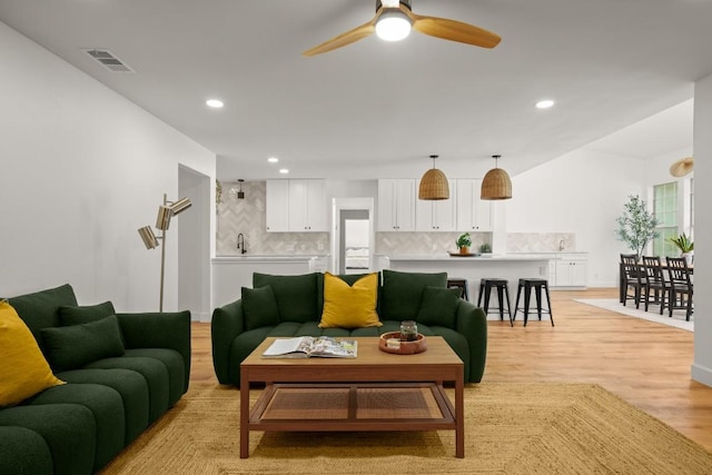 living room with ceiling fan, recessed lighting, visible vents, and light wood-type flooring